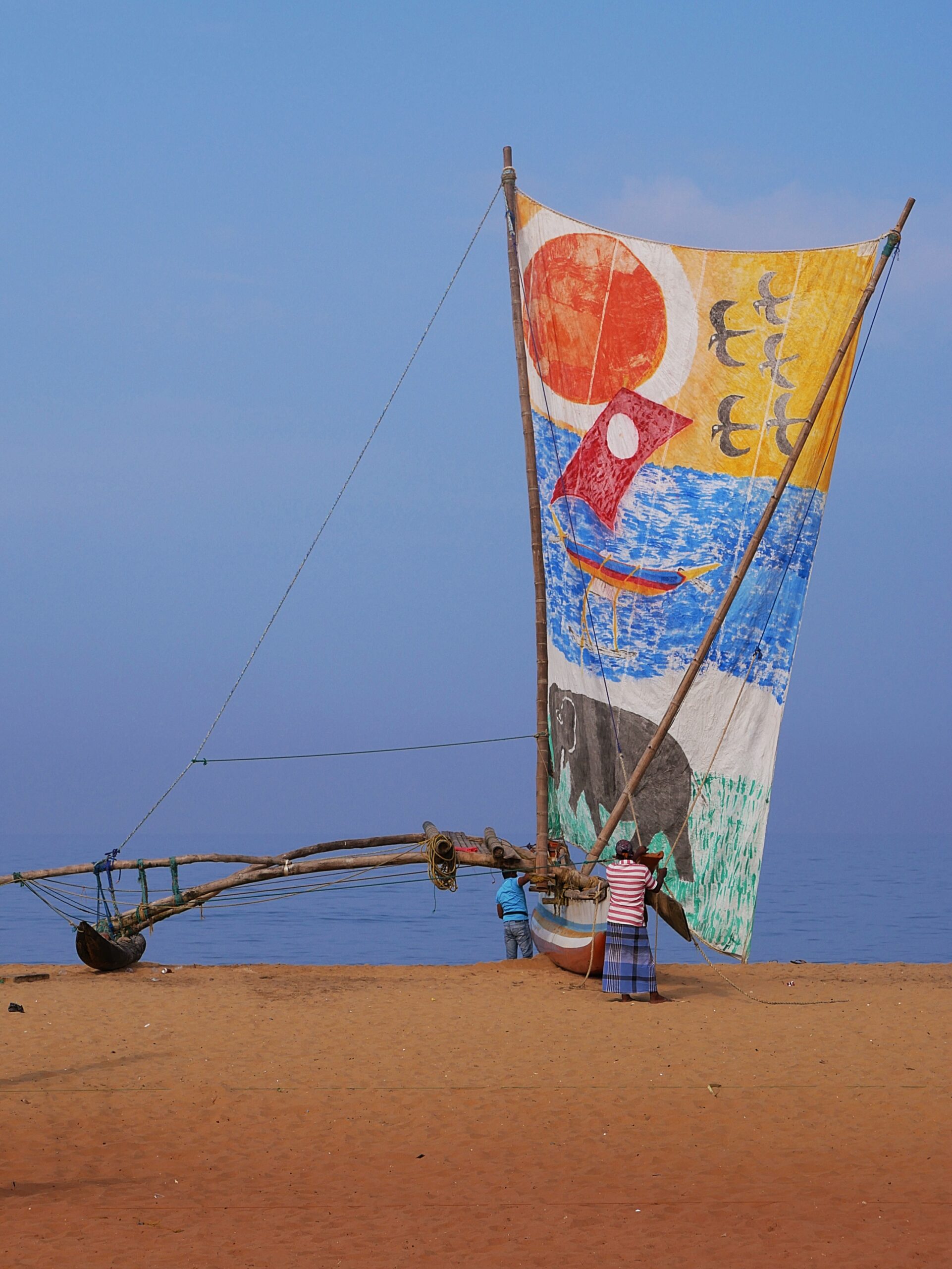 Sri Lankan men launch their sailing boat.